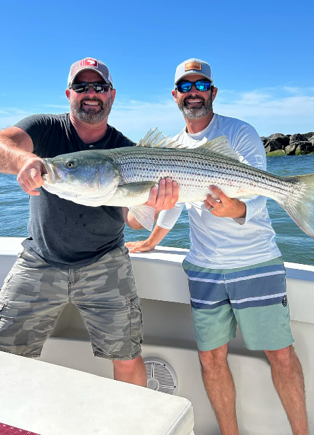 Two anglers holding a nice Ocean City striped bass.