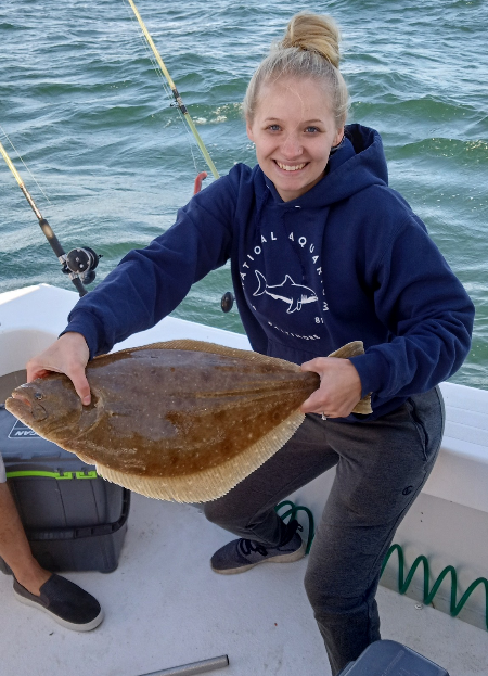 Lady angler holding a nice big flounder.