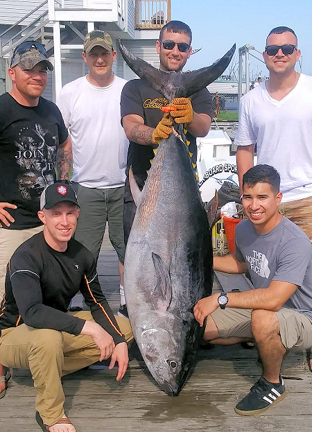 Huge Ocean City bluefin tuna being held by charter abgler.
